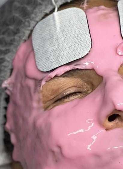 Cliente détendue sous un masque rose, électrode posée sur le front